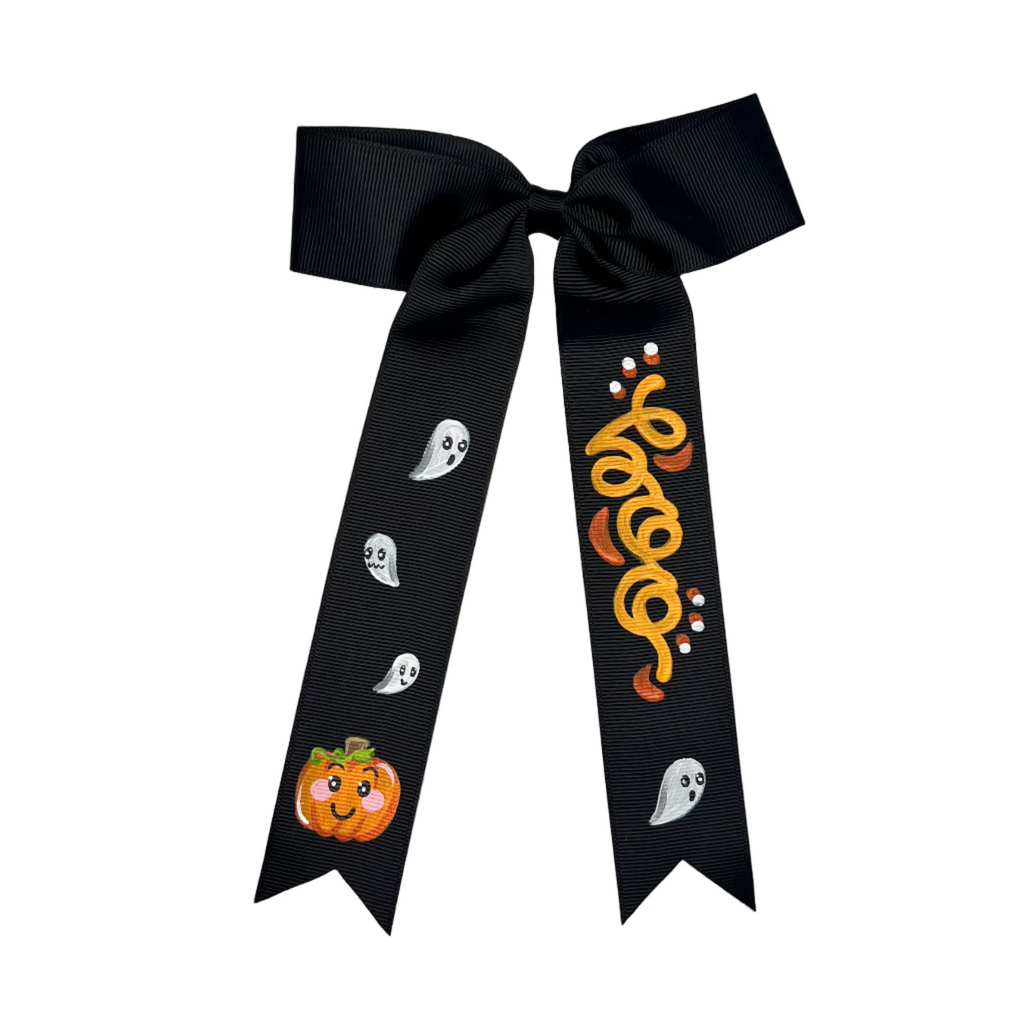 Black ribbon with Halloween-themed decorations on a white fabric background